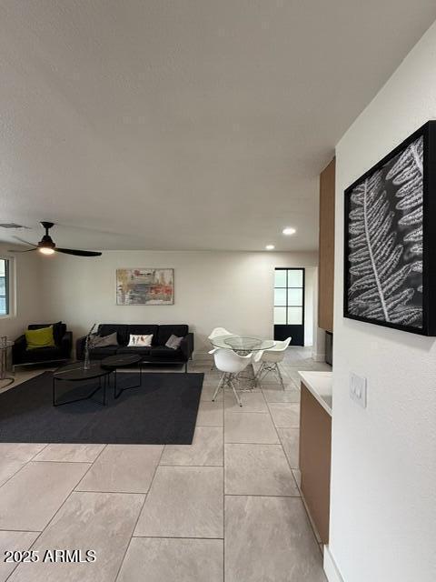 living room featuring a ceiling fan, recessed lighting, and light tile patterned floors