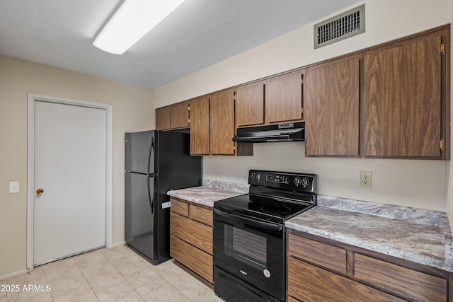 kitchen with light tile patterned floors, visible vents, under cabinet range hood, light countertops, and black appliances