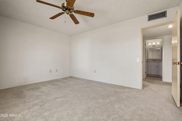 empty room with a textured ceiling, carpet, visible vents, and a ceiling fan