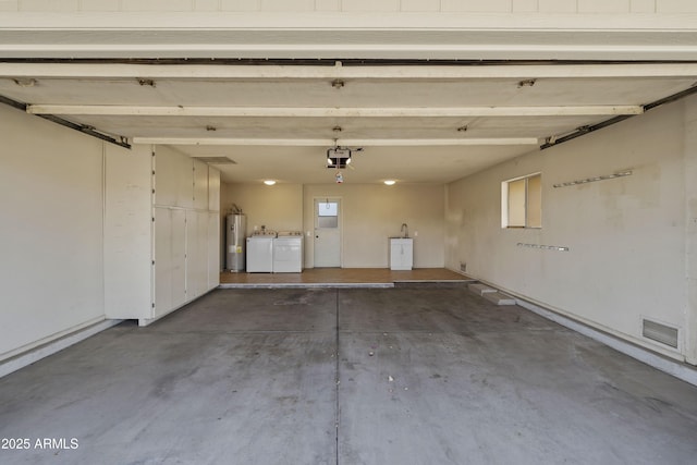 garage with a garage door opener, visible vents, electric water heater, and washer and clothes dryer