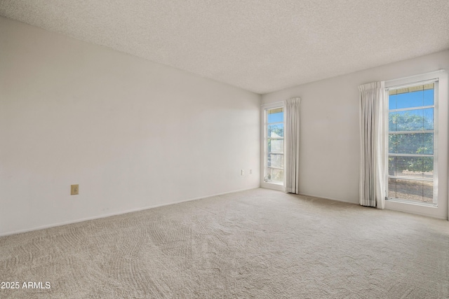 carpeted empty room with a textured ceiling