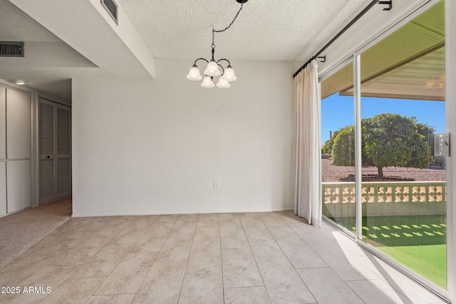 unfurnished room featuring tile patterned floors, visible vents, a textured ceiling, and an inviting chandelier