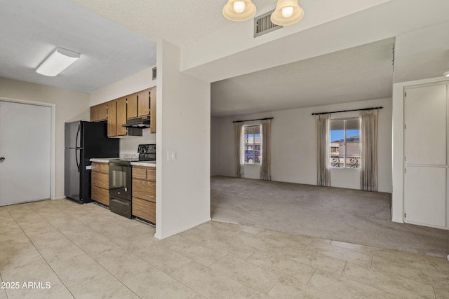 kitchen featuring light colored carpet, brown cabinets, under cabinet range hood, light countertops, and black appliances