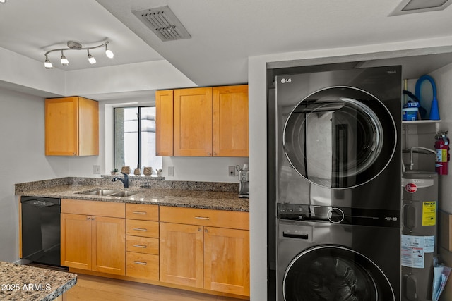 kitchen with electric water heater, a sink, visible vents, stacked washer / drying machine, and dishwasher