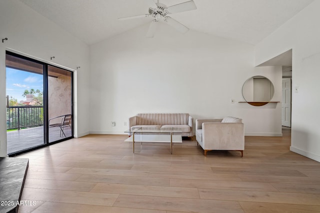 sitting room with light wood-style floors, ceiling fan, high vaulted ceiling, and baseboards