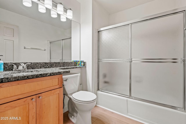 bathroom with tile patterned floors, vanity, toilet, and bath / shower combo with glass door