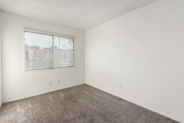 spare room with a textured ceiling, baseboards, and carpet flooring