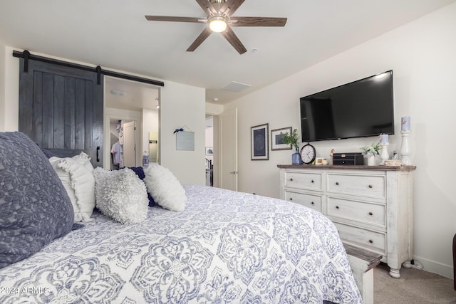 bedroom with baseboards, ceiling fan, carpet, and a barn door