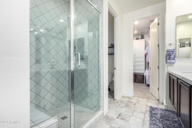 bathroom with vanity, recessed lighting, toilet, and a shower stall