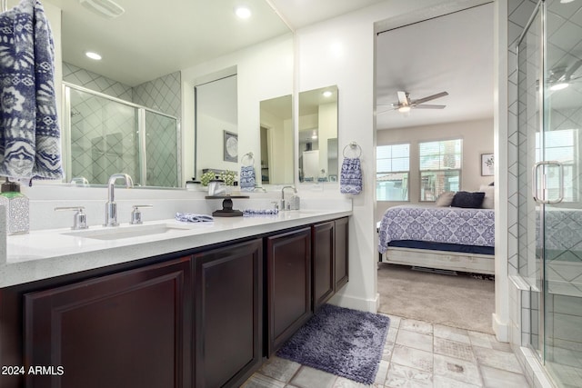 full bathroom featuring a sink, a ceiling fan, a stall shower, and double vanity