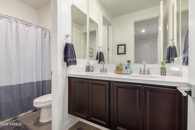 bathroom featuring a sink, tile patterned floors, toilet, and double vanity