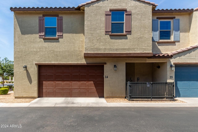 view of front of property with an attached garage, stucco siding, and a tiled roof