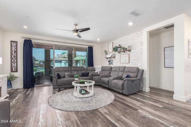 living room featuring ceiling fan, visible vents, wood finished floors, baseboards, and recessed lighting