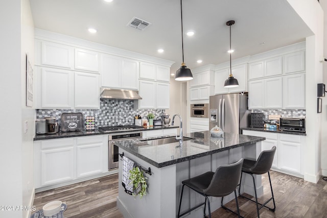 kitchen featuring visible vents, decorative backsplash, white cabinets, a sink, and stainless steel appliances