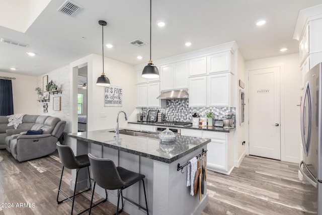 kitchen featuring under cabinet range hood, appliances with stainless steel finishes, visible vents, and a sink