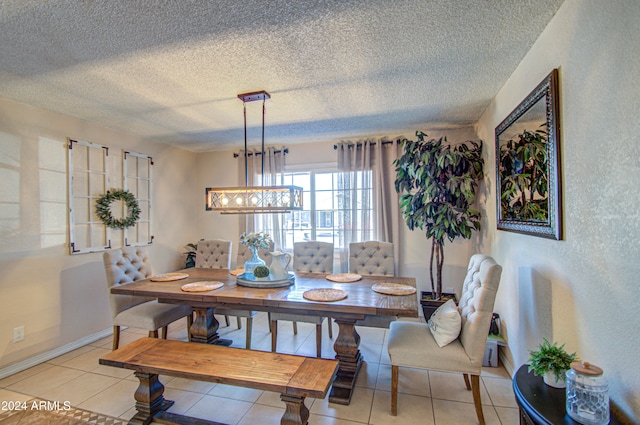 tiled dining space featuring a textured ceiling