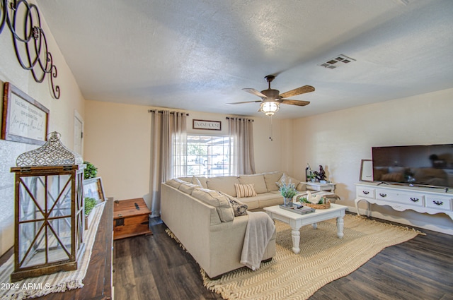 living room with ceiling fan, dark hardwood / wood-style flooring, and a textured ceiling