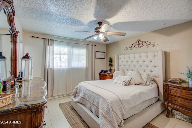 tiled bedroom with ceiling fan and a textured ceiling