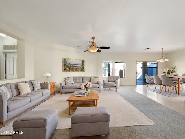 living room with ceiling fan with notable chandelier and light tile patterned flooring