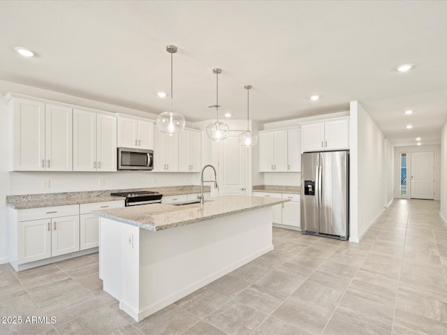 kitchen with white cabinets, sink, an island with sink, appliances with stainless steel finishes, and light stone counters