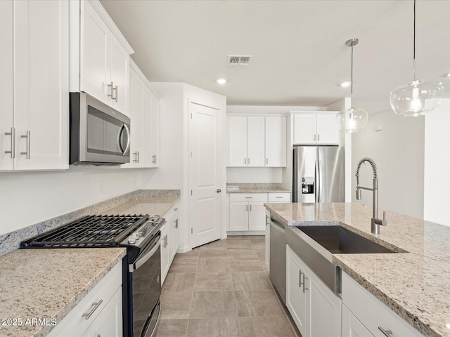 kitchen with stainless steel appliances, white cabinetry, and sink