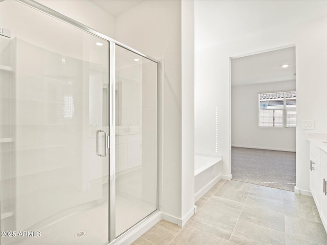 bathroom featuring tile patterned flooring, vanity, and shower with separate bathtub