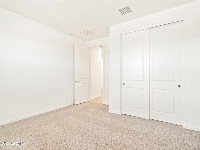 unfurnished bedroom featuring a closet and light colored carpet