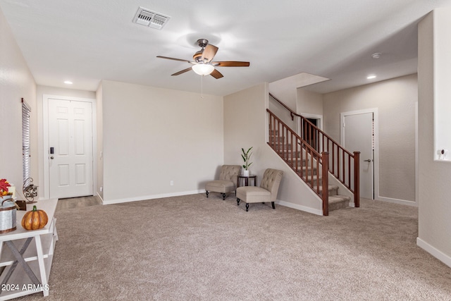 living area with carpet and ceiling fan