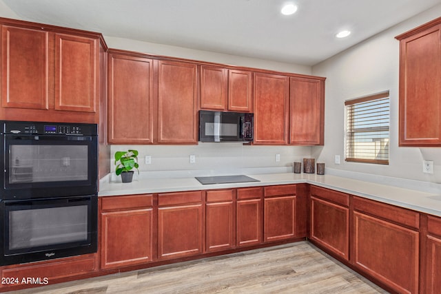 kitchen featuring black appliances and light hardwood / wood-style flooring