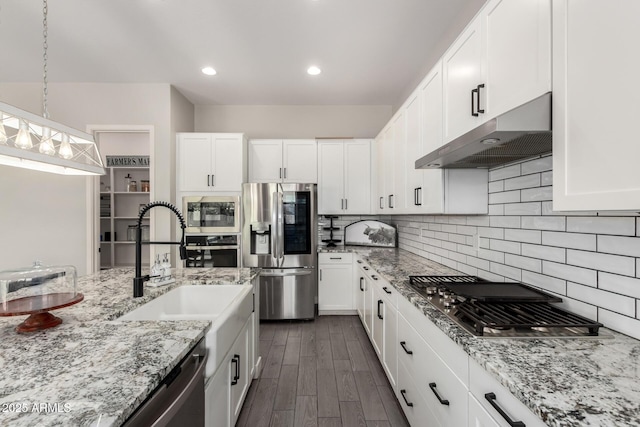 3938 E Appaloosa Rd, Gilbert, AZ 85296 - kitchen featuring appliances with stainless steel finishes, under cabinet range hood, white cabinetry, light stone countertops, and recessed lighting
