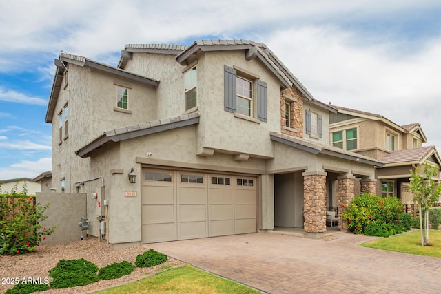 3938 E Appaloosa Rd, Gilbert, AZ 85296 - view of front of home featuring an attached garage, stone siding, decorative driveway, and stucco siding