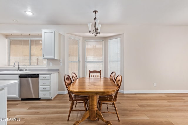 dining space featuring sink, a chandelier, and light hardwood / wood-style floors