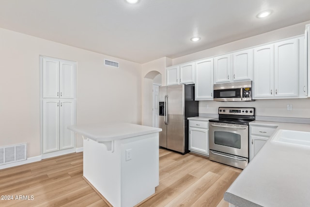 kitchen featuring white cabinets, stainless steel appliances, and light hardwood / wood-style flooring