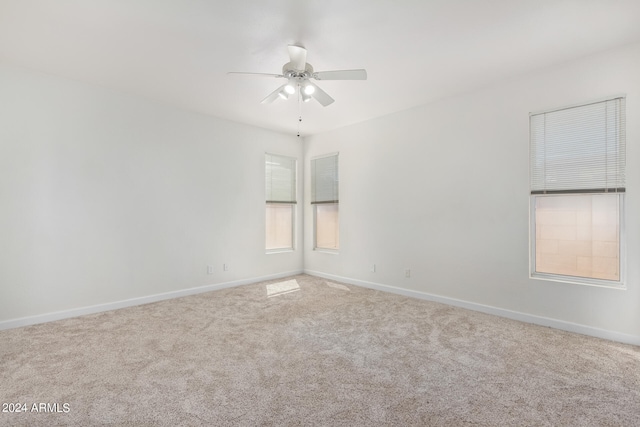 carpeted spare room with ceiling fan