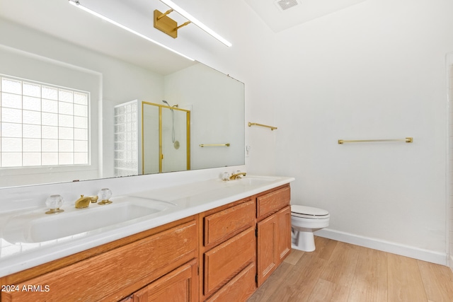 bathroom with vanity, hardwood / wood-style flooring, a shower with shower door, and toilet