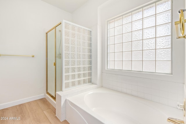 bathroom featuring shower with separate bathtub, wood-type flooring, and plenty of natural light