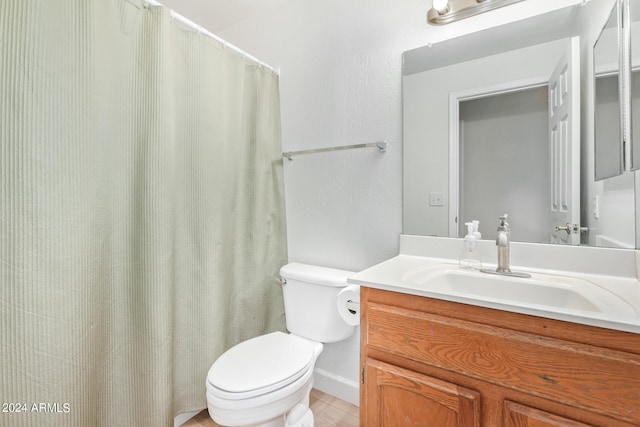 bathroom featuring curtained shower, vanity, and toilet