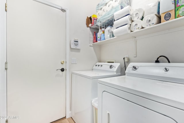 washroom with light hardwood / wood-style flooring and washing machine and dryer