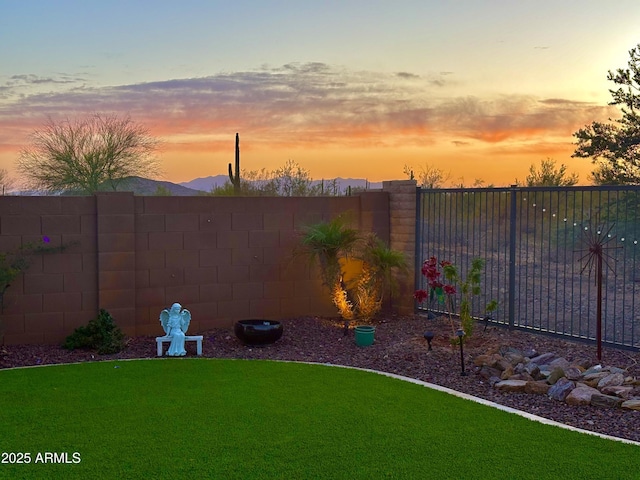 yard at dusk with a fenced backyard