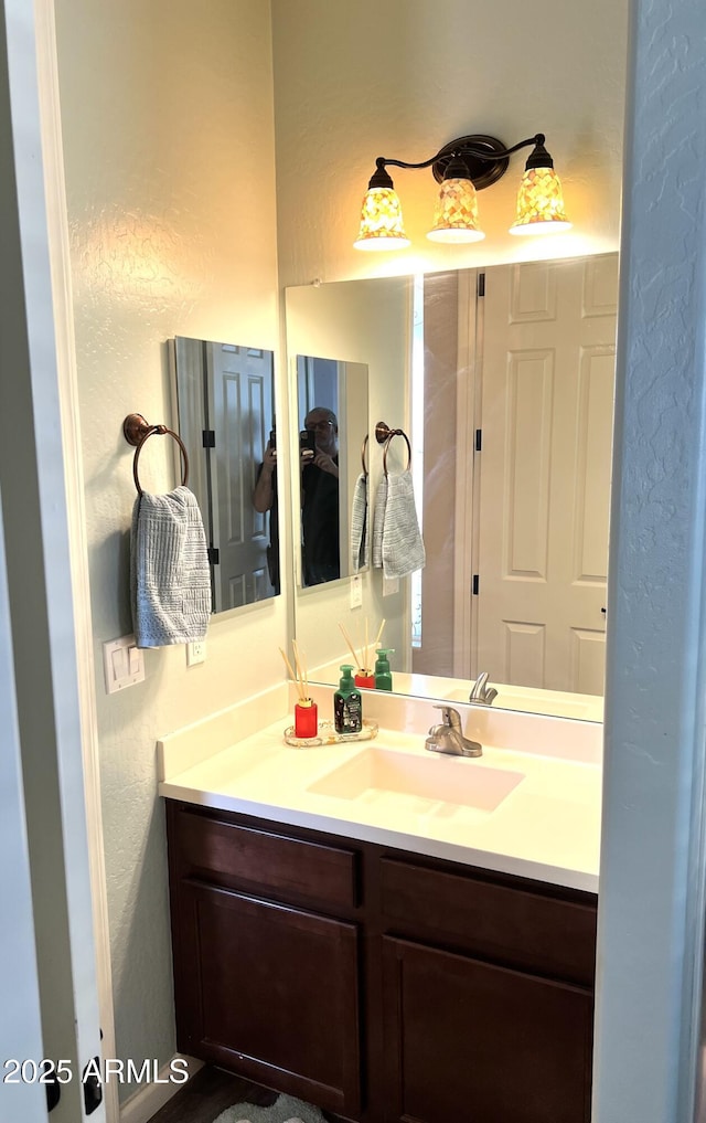 bathroom featuring a textured wall and vanity