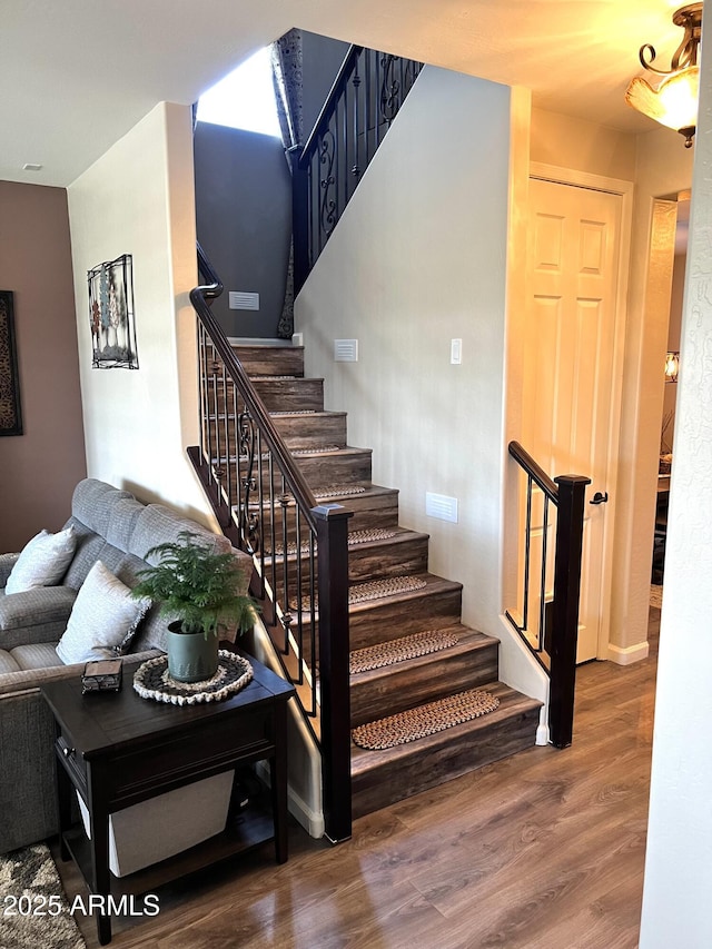 stairs featuring wood finished floors