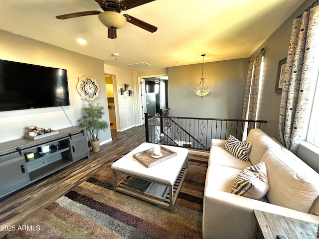 living room featuring ceiling fan, baseboards, and wood finished floors