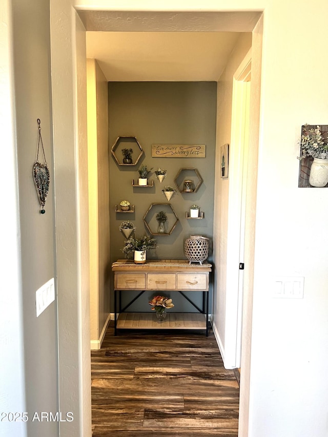 hallway featuring baseboards and dark wood-style flooring