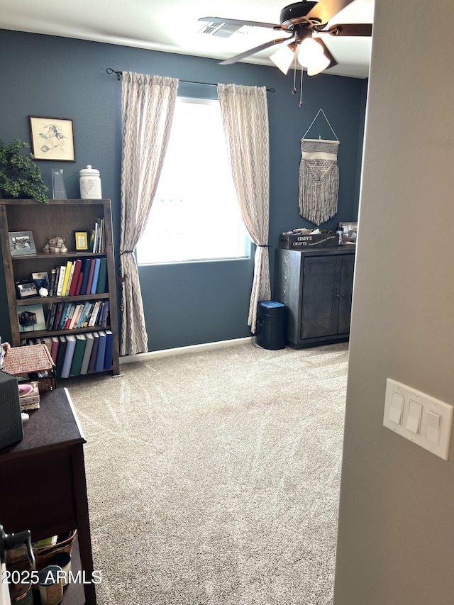 interior space featuring a ceiling fan, carpet flooring, and baseboards