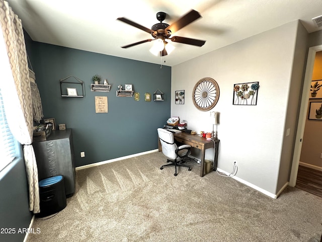 carpeted office with visible vents, baseboards, and a ceiling fan