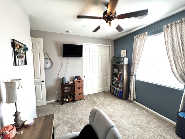 interior space with carpet floors, baseboards, and a ceiling fan