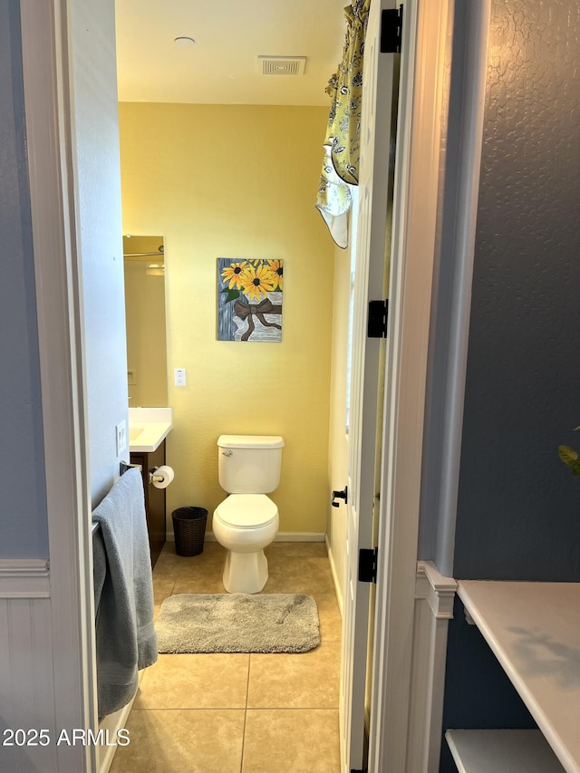 bathroom with tile patterned flooring, visible vents, vanity, and toilet