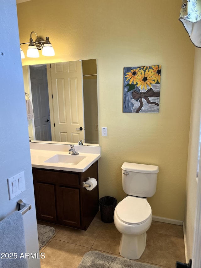 bathroom with tile patterned flooring, vanity, and toilet