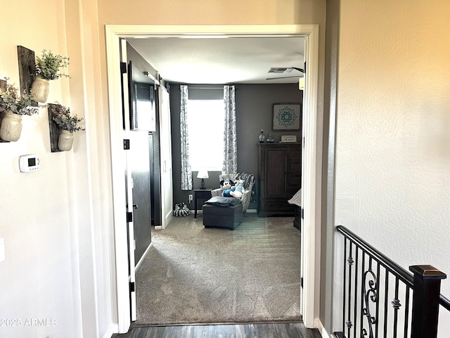 hallway with baseboards and visible vents