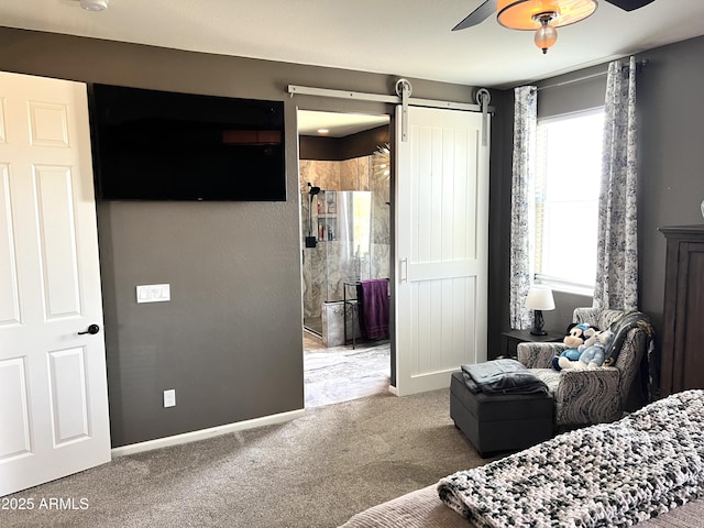 bedroom with connected bathroom, a barn door, ceiling fan, and carpet